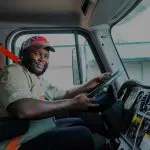 A man sitting in the drivers seat of a truck.