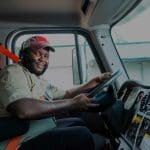 A man sitting in the drivers seat of a truck.